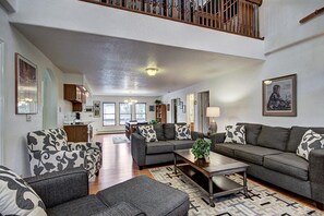 A spacious living room with a high ceiling, a staircase, and a dining area in the background. - Casa De Alta in Breckenridge (Breckenridge)
