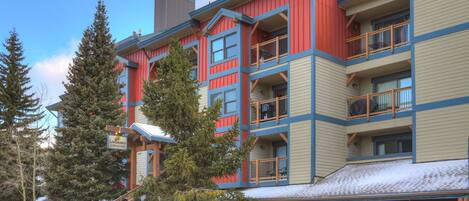 A multi-story building with balconies, a staircase, and a sign indicating a Longbranch Inn.