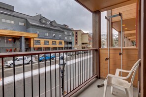 A balcony with a view of a street, a chair, and a building with multiple floors and windows. - Der Steiermark 101 in Breckenridge (Breckenridge)