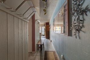 A hallway with a bench, a textured wall, and a decorative metal piece. - Der Steiermark 101 in Breckenridge (Breckenridge)