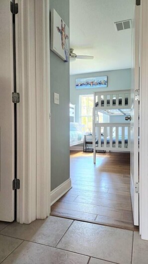 A hallway with a white door, a white railing, and a painting on the wall. - House w/Private Pool/Near Beach+Attractions (Panama City)