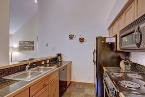 A kitchen with a double sink, stainless steel appliances, and a stove. - Los Pinos D-24 in Breckenridge (Breckenridge)