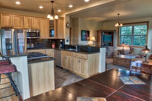 A kitchen with wooden cabinets, a built-in stove, a microwave, and a large island with a sink. - 120 Rachel Lane in Breckenridge (Breckenridge)