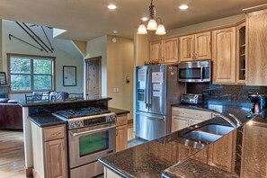 A modern kitchen with granite countertops, stainless steel appliances, and wooden cabinetry. - 120 Rachel Lane in Breckenridge (Breckenridge)