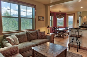 A living room with a sofa, coffee table, and a dining area with a table and chairs. - 120 Rachel Lane in Breckenridge (Breckenridge)
