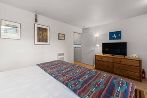 A bedroom with a bed, a dresser, a television, and framed artwork on the wall. - New Listing! Budget Friendly, Prime Location, Private Deck (Telluride)