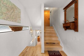 A wooden staircase leading to a room with a wooden floor, a mirror, and a map on the wall. - New Listing! Budget Friendly, Prime Location, Private Deck (Telluride)
