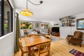 A living room with a wooden dining table, chairs, a sofa, a television, and a bookshelf. - New Listing! Budget Friendly, Prime Location, Private Deck (Telluride)