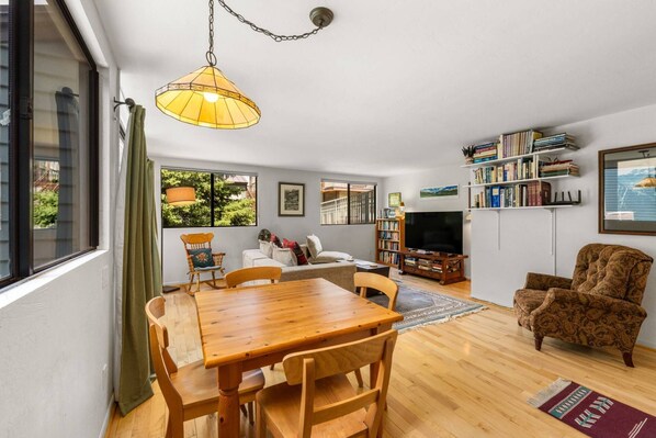 A living room with a wooden dining table, chairs, a sofa, a television, and a bookshelf. - New Listing! Budget Friendly, Prime Location, Private Deck (Telluride)