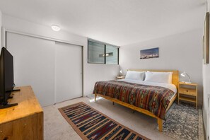 A bedroom with a bed, bedside tables, a TV, a window, and a door. - New Listing! Budget Friendly, Prime Location, Private Deck (Telluride)
