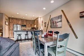 A compact kitchen with wooden cabinets, a microwave, and a bar area. - Liftside Retreat in Breckenridge (Breckenridge)