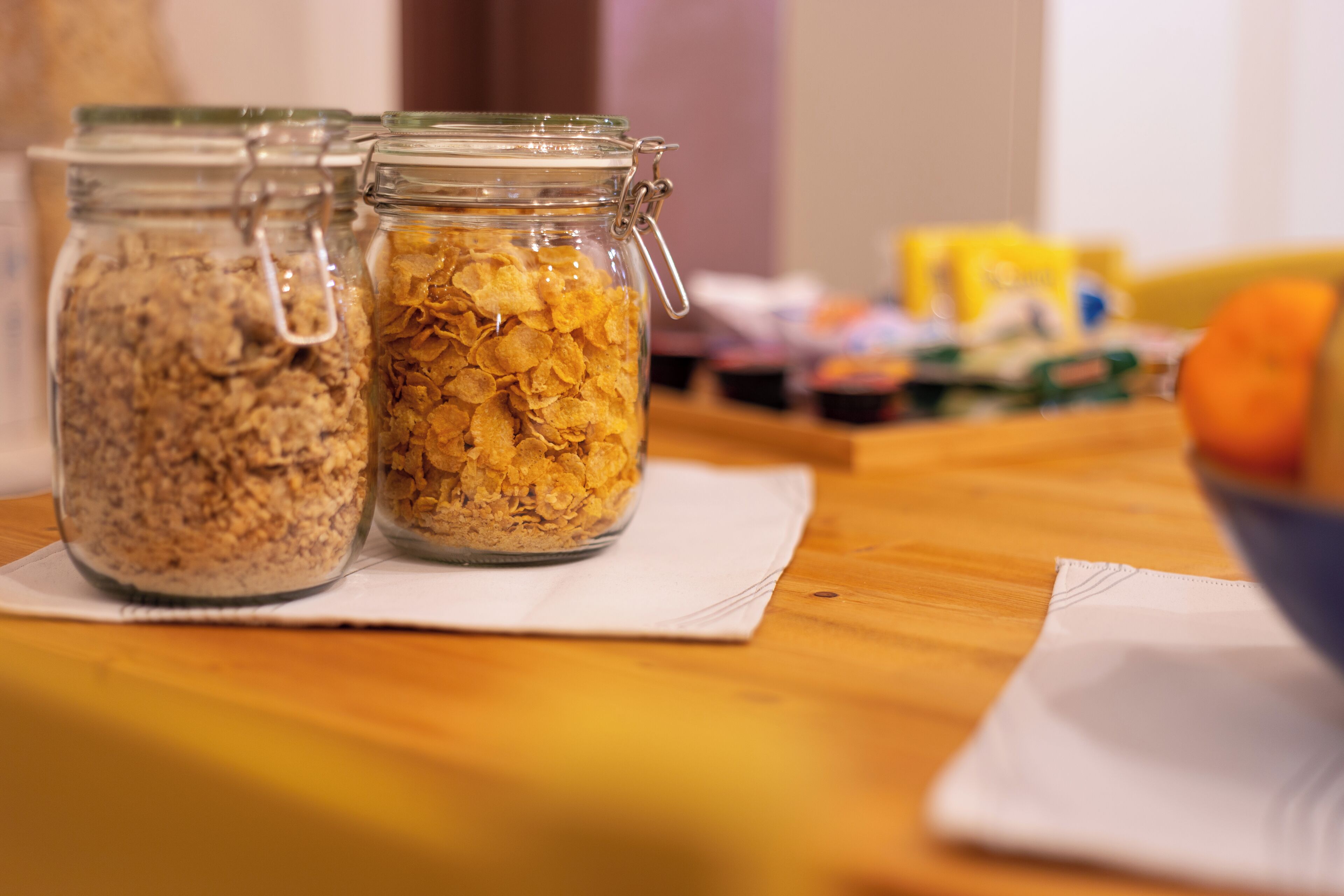 Two glass jars with metal clasps on a wooden table.