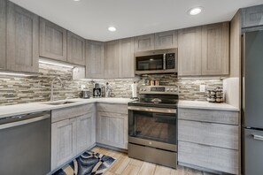 A modern kitchen with wooden cabinets, a stainless steel oven, and a microwave. - Der Steiermark 219 in Breckenridge (Breckenridge)