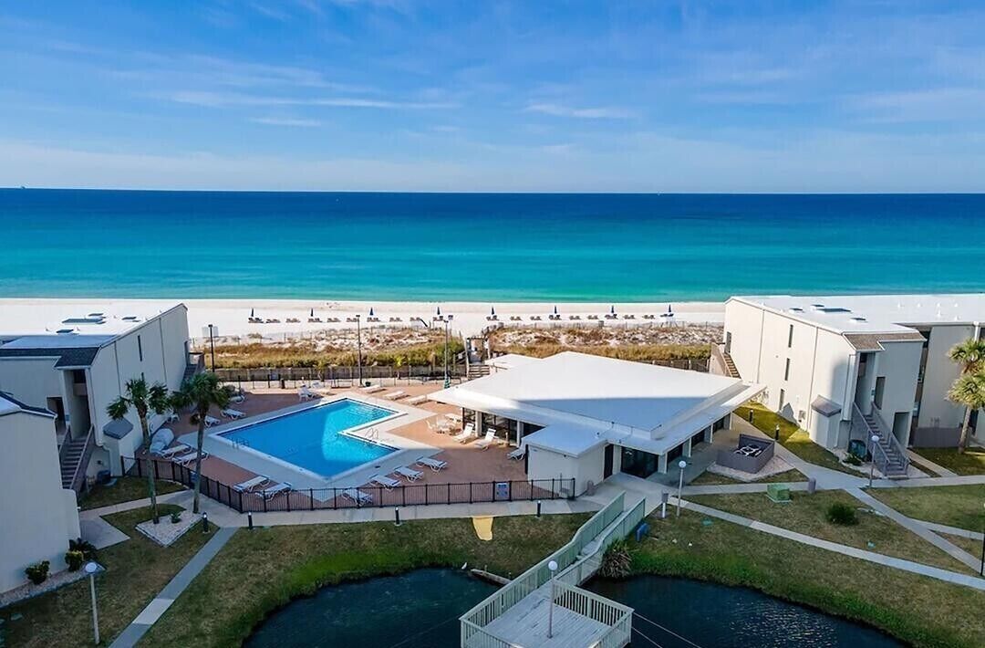 Een resort met een zwembad, toegang tot het strand en uitzicht op de oceaan.