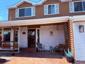 A two-story house with a covered porch, a brick exterior, and a wooden number sign. - Spacious 4-bedroom house in welcoming Thornton, Cozy for families to relax. (Thornton)