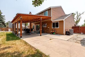 A residential house with a covered patio, a visible chimney, and a fenced backyard. - Spacious 4-bedroom house in welcoming Thornton, Cozy for families to relax. (Thornton)