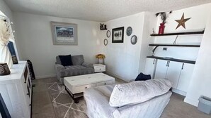 A compact living space with a sofa, a coffee table, a dining area, and a kitchen. - Spacious 4-bedroom house in welcoming Thornton, Cozy for families to relax. (Thornton)