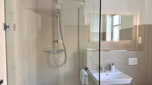 A modern bathroom with a glass shower enclosure, a white sink, and a mirror. - Warnemünder Auszeit 2 (Rostock)