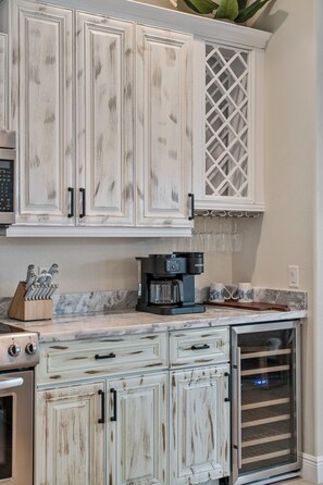 A kitchen with white cabinetry, a coffee maker, and a microwave. - Blue Tide Waterfront Pool & Hot Tub 2 En Suites (Cape Coral)
