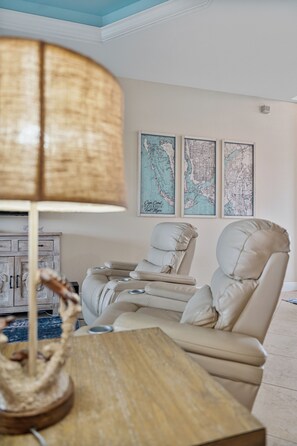 A room with a beige sofa, a wooden coffee table, and a lamp. There are three framed maps on the wall. - Blue Tide Waterfront Pool & Hot Tub 2 En Suites (Cape Coral)