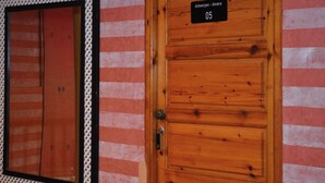 A wooden door with a sign reading 'Antwerpen - Anvers 05' and a striped wall.