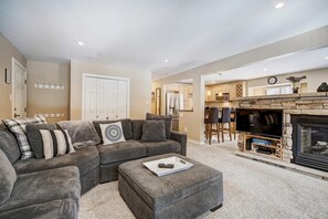 A living room with a grey sectional sofa, a fireplace, and a television. - Tanenbaum BTR 201 in Columbine Rd (Columbine Rd)
