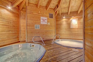 A wooden spa with two hot tubs, a sign indicating spa hours, and a tub rules notice. - Tyra Lookout #22 in Breckenridge (Breckenridge)