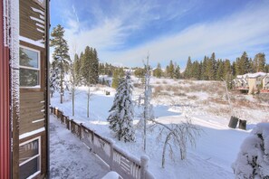 Eine verschneite Landschaft mit einem Holzbau, schneebedeckten Bäumen und einem klaren Himmel.