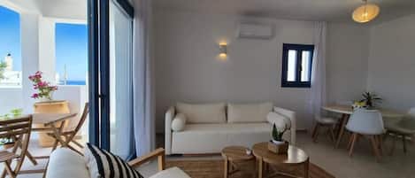 Una sala moderna con sofá, mesa de centro y comedor.