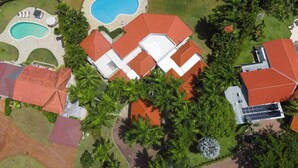 An aerial view of a residential area with multiple houses, a swimming pool, and lush greenery. - Villa Casamare Oceanfront Luxury in SeaHorseRanch (Sosúa)