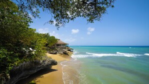 A beach with a structure on a rocky outcrop, overlooking the ocean. - Villa Casamare Oceanfront Luxury in SeaHorseRanch (Sosúa)