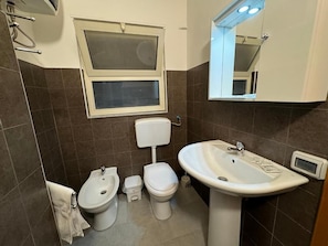 Un baño con bidé, inodoro y lavamanos.