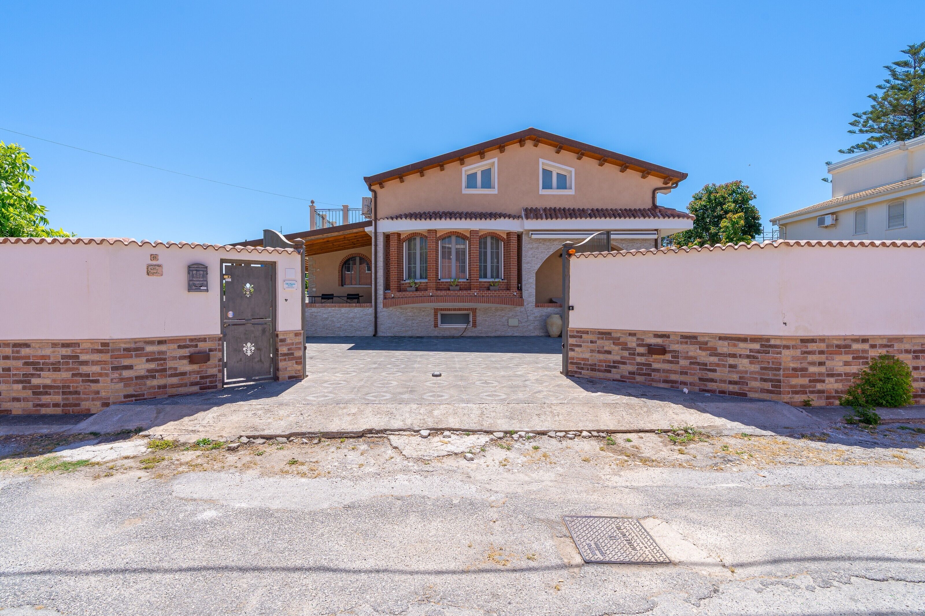 Uma casa de dois andares com entrada frontal, um pequeno alpendre e uma garagem.