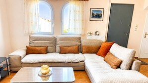 Ein Wohnzimmer mit einer Couch, einem Couchtisch und einer Tür.