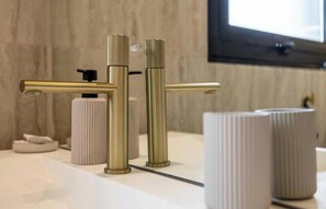 Ein Badezimmer mit modernem Wasserhahn und einer Seifenspender.