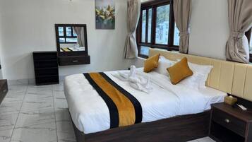 Habitación de hotel con cama, mesita de noche, espejo y ventana con cortinas.