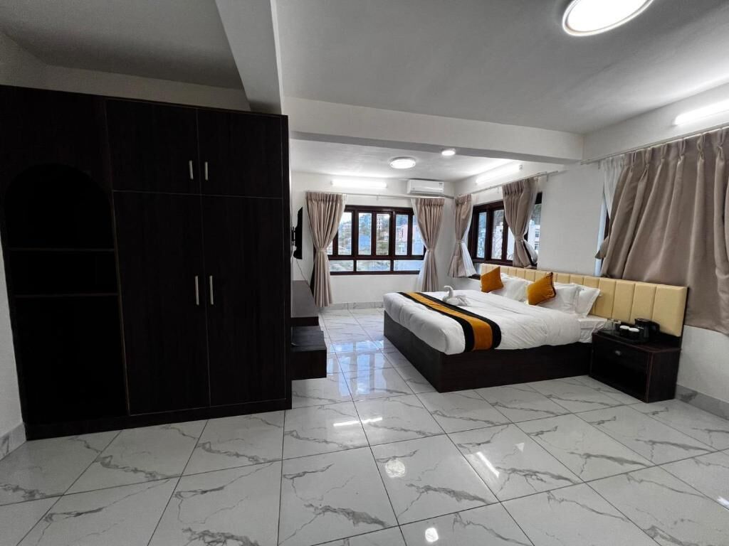 Un dormitorio con cama, armario, cortinas y suelo de baldosas.
