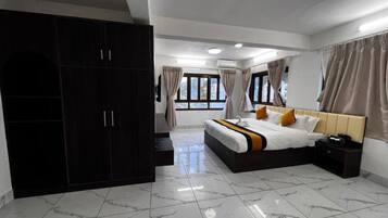 Un dormitorio con cama, armario, cortinas y suelo de baldosas.