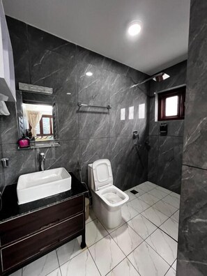 A bathroom with a bathtub, toilet, and a shower area. - Mandala Resorts and Events (Sanga)