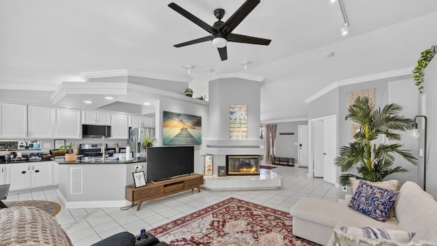 A modern living room with a fireplace, a television, and a kitchen area. - Unwind in Henderson | Pool, Spa & Spacious Retreat (Henderson)