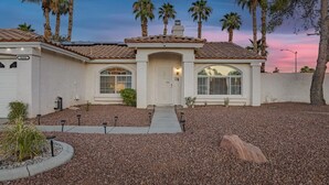 A two-story house with a tiled roof, a front entrance, and a driveway leading to the garage. - Unwind in Henderson | Pool, Spa & Spacious Retreat (Henderson)