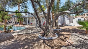 A pool area with trees, a pergola, and a small building. - Unwind in Henderson | Pool, Spa & Spacious Retreat (Henderson)