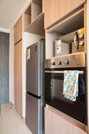 Eine moderne Küche mit einem Edelstahl-Kühlschrank, Backofen und einer eingebauten Mikrowelle.