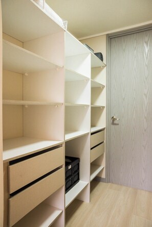 Ein Zimmer mit einer eingebauten Regaleinheit, einer Tür und einem gefliesten Boden.