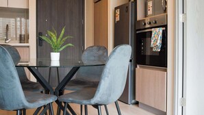 Cocina moderna con una mesa de comedor, sillas y un refrigerador.