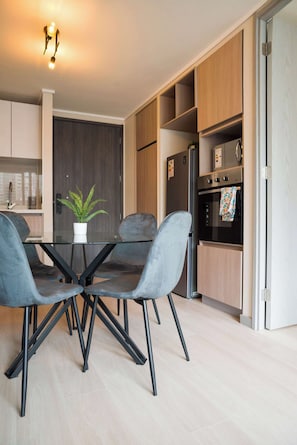 Eine moderne Küche mit Esstisch, Stühlen und einem Kühlschrank.