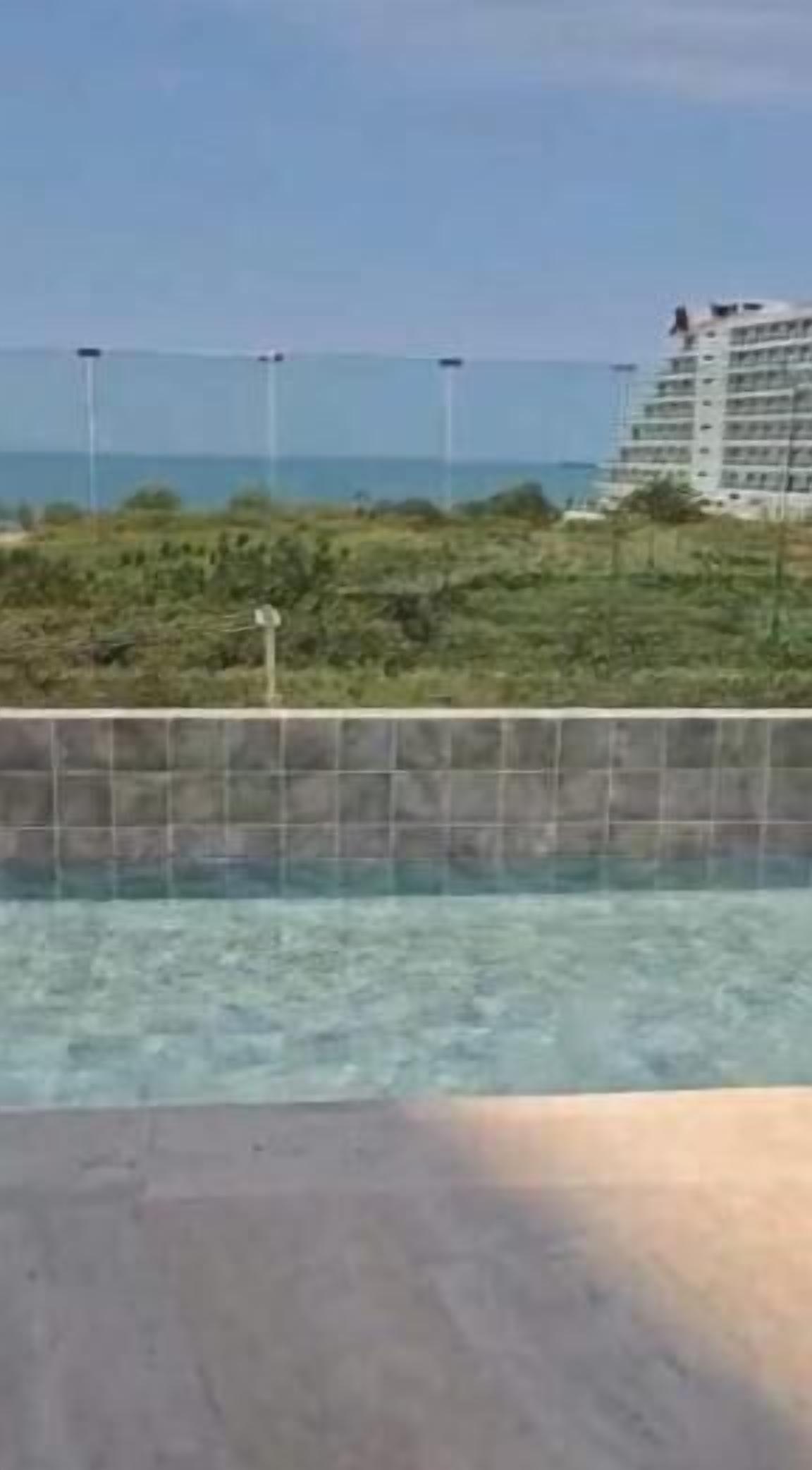 Une piscine avec vue sur la mer et un bâtiment en arrière-plan.