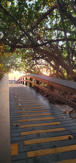 A wooden bridge with yellow tactile paving leading to a building. - Marco Island --- Stay in Paradise! (Marco Island)