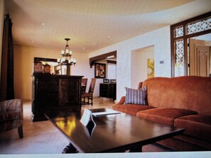Ein Wohnzimmer mit einer Couch, einem Couchtisch und einer Deckenleuchte.