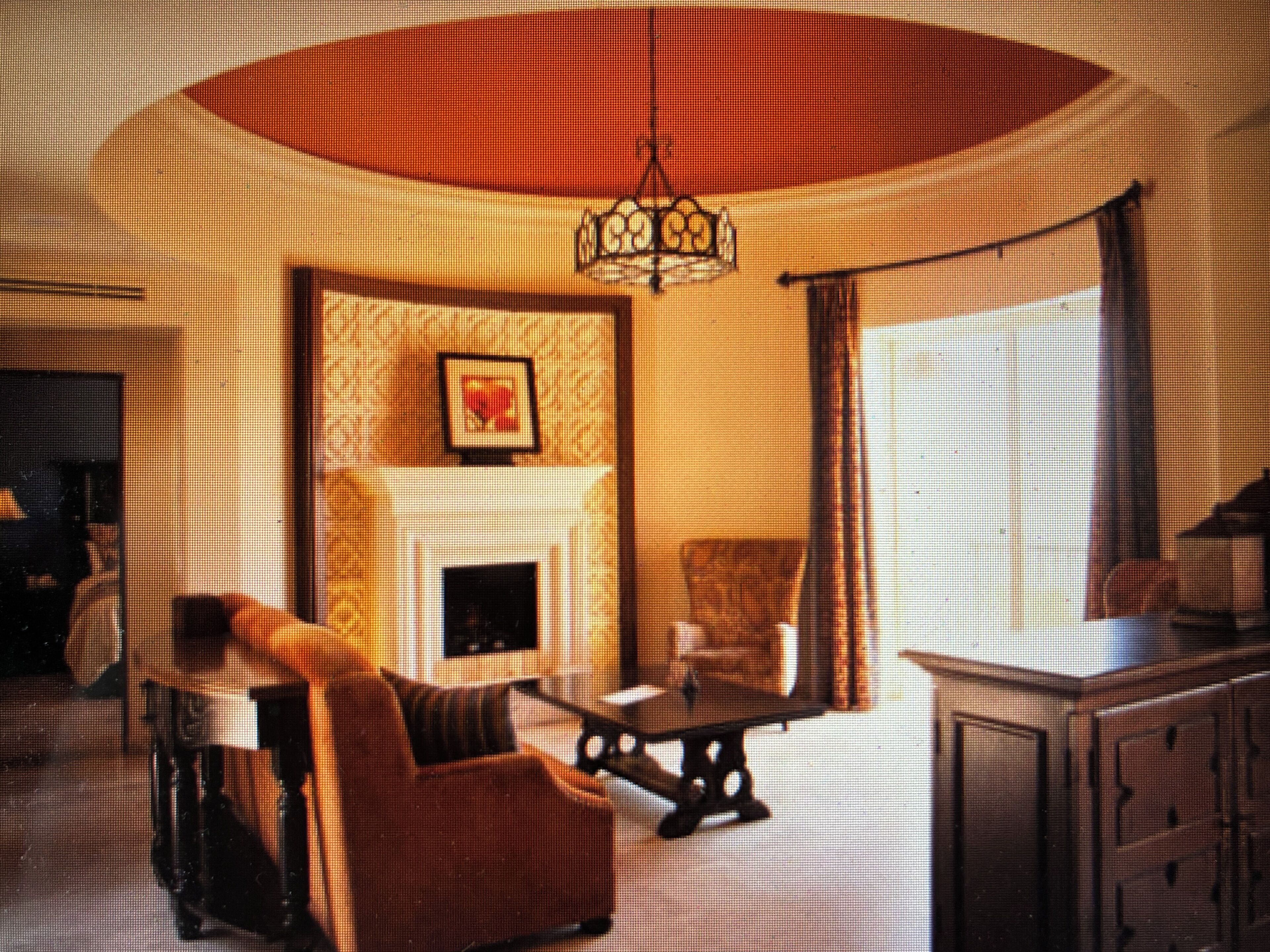 A room with a fireplace, a sofa, a table, and a cabinet.